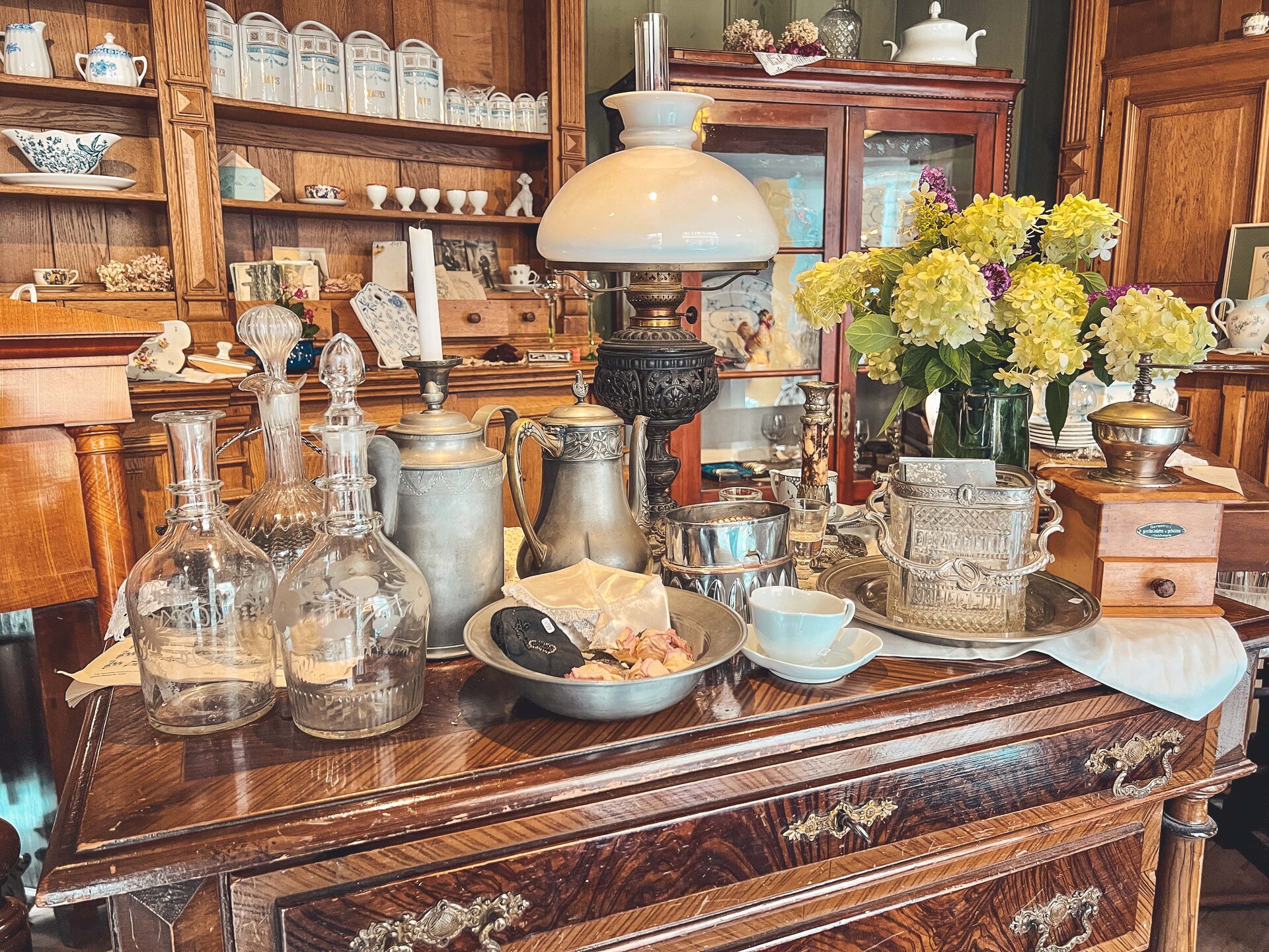 Blick auf die Ladenzeile mit Porzellan, Vitrine und Petroleumlampe